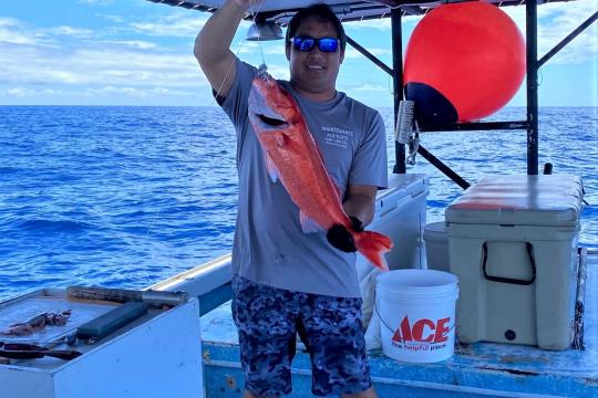 Captain Layne Nakagawa of the F/V Naomi K holding an ehu. Photo courtesy of Pacific Islands Fisheries Group/Fishing Vessel Naomi K.