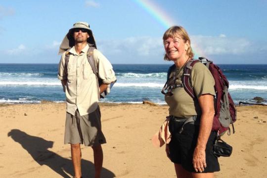 Diana Pike on the right with NOAA Fisheries colleague on the left on the beach with a rainbow in the background