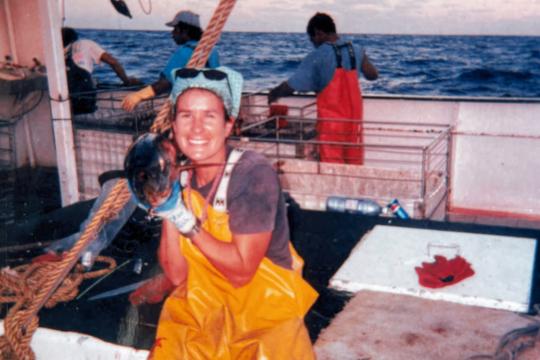 Woman posing with a small tuna onboard ship as a Hawai‘i-based longline observer