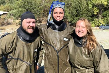 Three veterans corps participants pose in snorkeling gear after monitoring a stream restoration project.