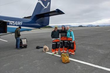 Group photo of survey team standing in front of a NOAA Twin Otter aircraft on the tarmac.