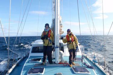Two scientists stand on boat during marine mammal survey in Scotland