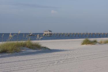 On a Mississippi Gulf Coast beach looking out to the water with a pier.