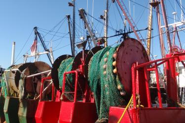 Stern view of  fishing vessells with their trawl nets. 