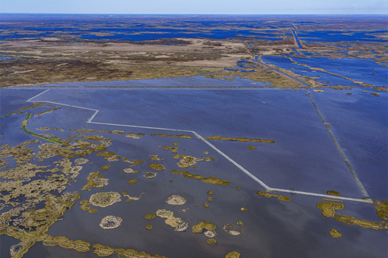 Aerial image of wetlands, open water, and containment dikes