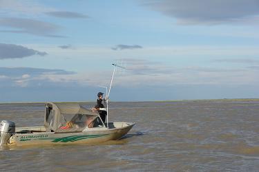 man in boat using equipment to listen for beluga whales in Cook Inlet, Alaska