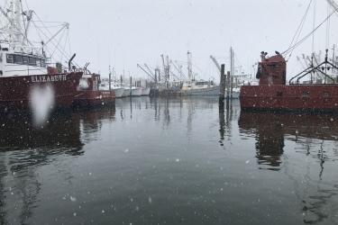 Snowy Viking village port, fishing vessels at the docks. 